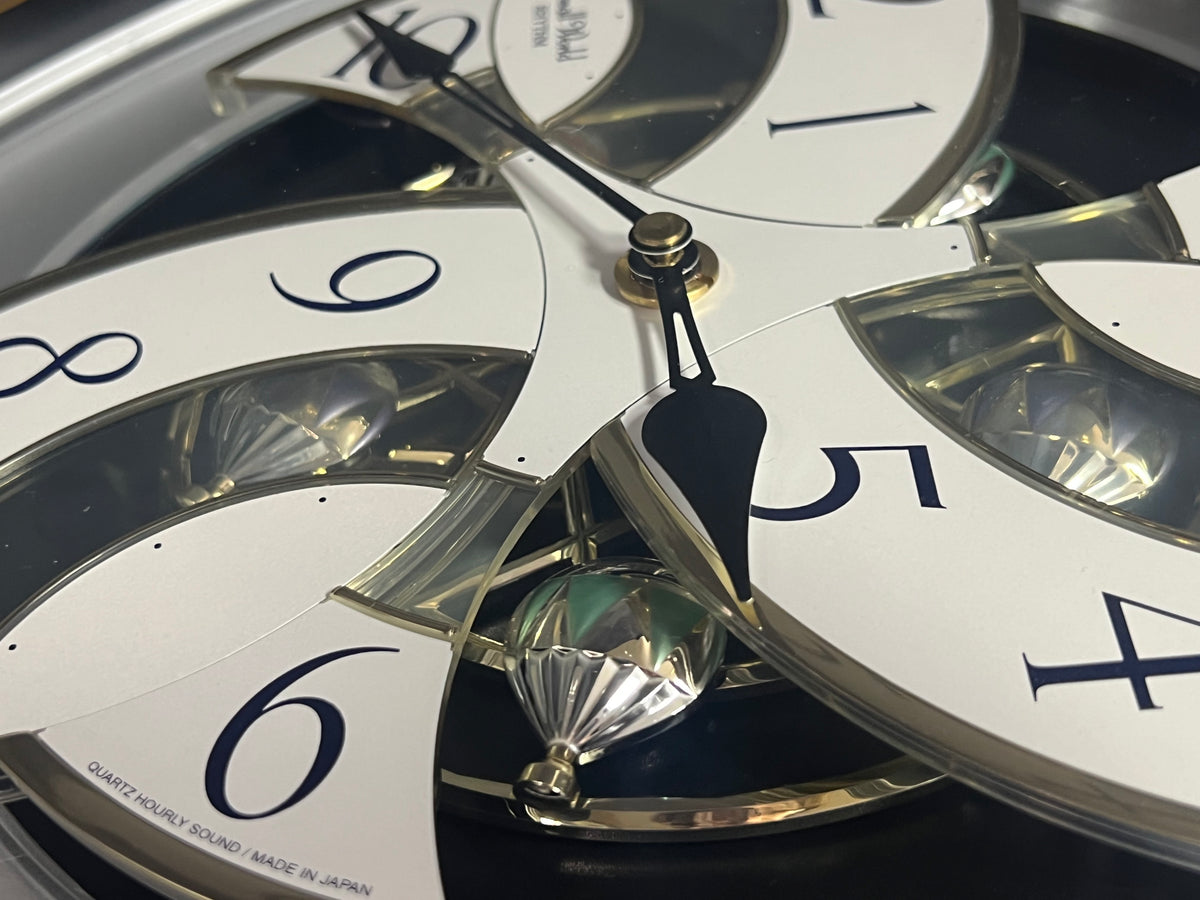 Rhythm “Tri-Cracker” Moving Dial Magic Motion Musical Wall Clock with Popular Melodies - 4MH759NR06