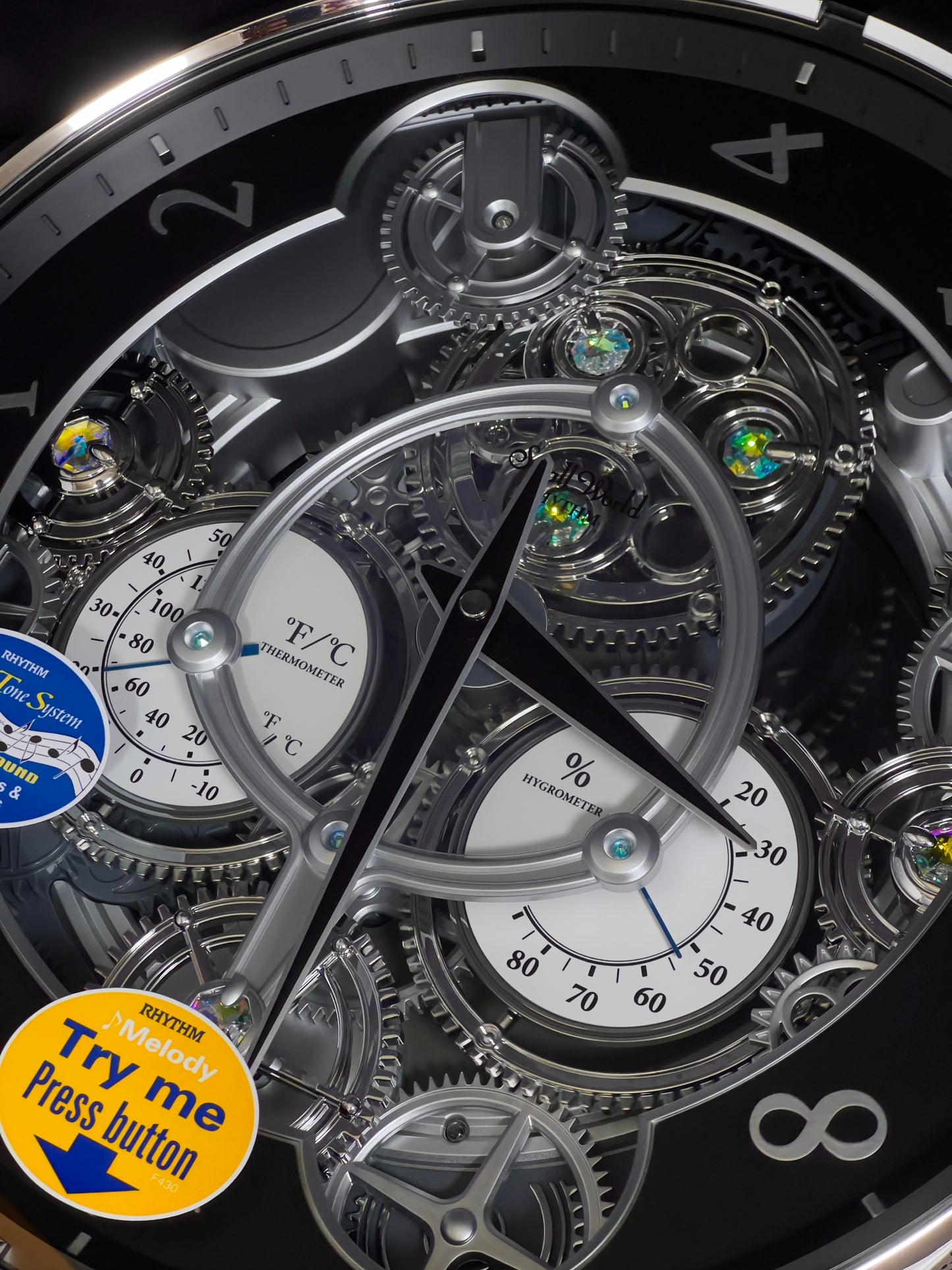 Rhythm “Chronograph (Black/Silver)” Skeletonized Dial Magic Motion Musical Wall Clock with Moving Gears - 4MH442WU08