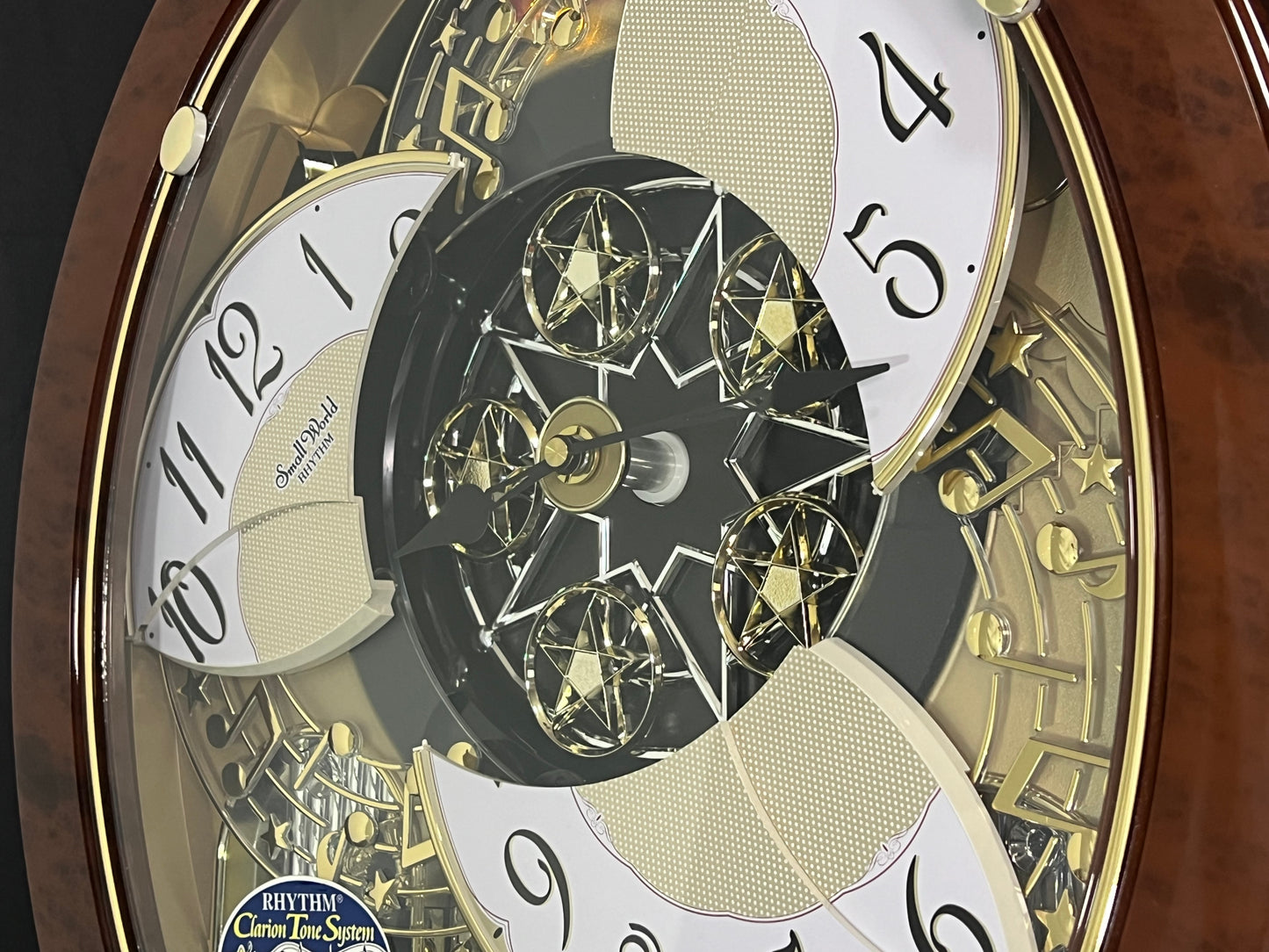 Rhythm "Woodgrain Stars" Moving Dial Magic Motion Musical Wall Clock - 4MH843WS23
