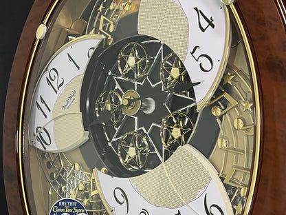 Rhythm "Woodgrain Stars" Moving Dial Magic Motion Musical Wall Clock - 4MH843WS23