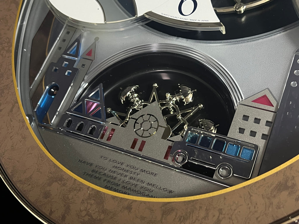 Rhythm “Tri-Cracker” Moving Dial Magic Motion Musical Wall Clock with Popular Melodies - 4MH759NR06
