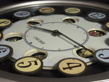 Seiko QXM106SRH "Twirling Numbers" Melodies in Motion Musical Wall Clock with Moving Dial