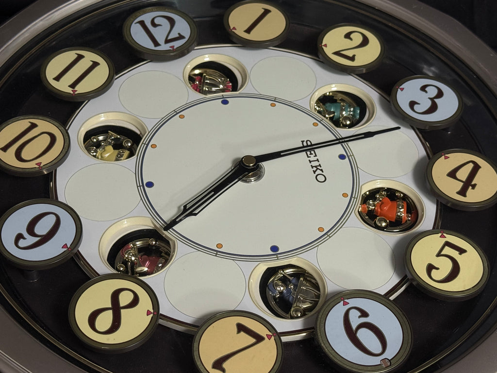 Seiko QXM106SRH "Twirling Numbers" Melodies in Motion Musical Wall Clock with Moving Dial