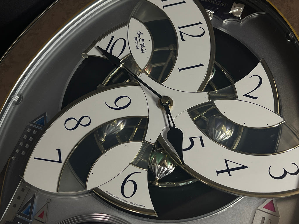 Rhythm “Tri-Cracker” Moving Dial Magic Motion Musical Wall Clock with Popular Melodies - 4MH759NR06